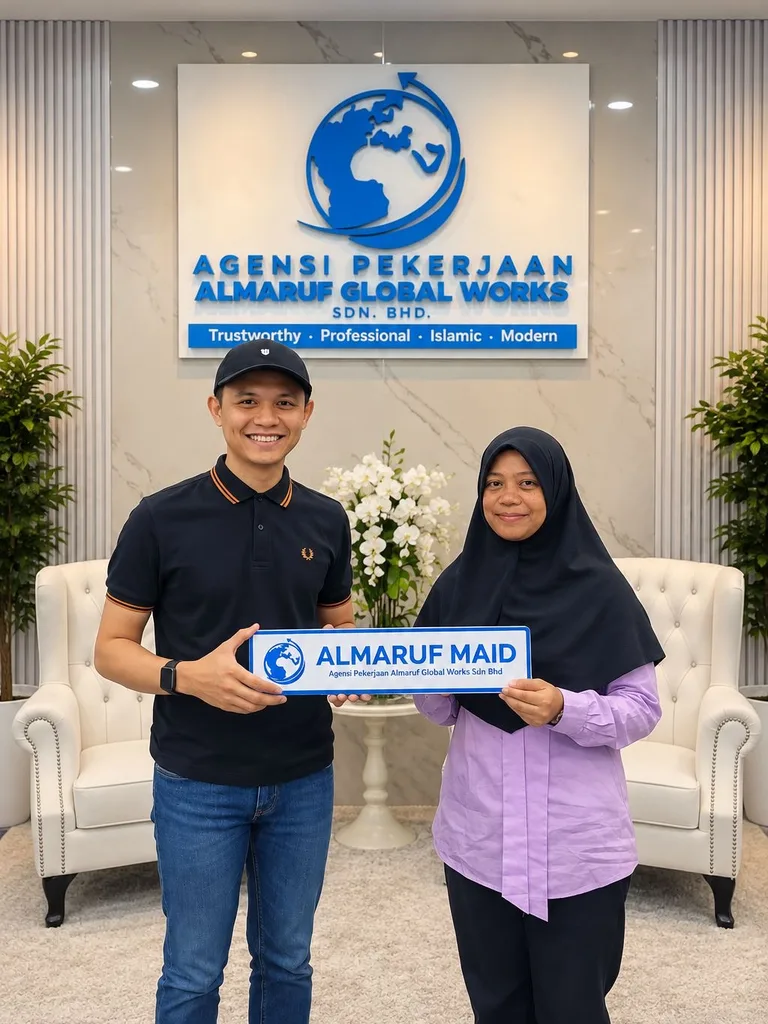A man in a cap and a woman in a black headscarf holding an Almaruf Maid plate at the Almaruf office